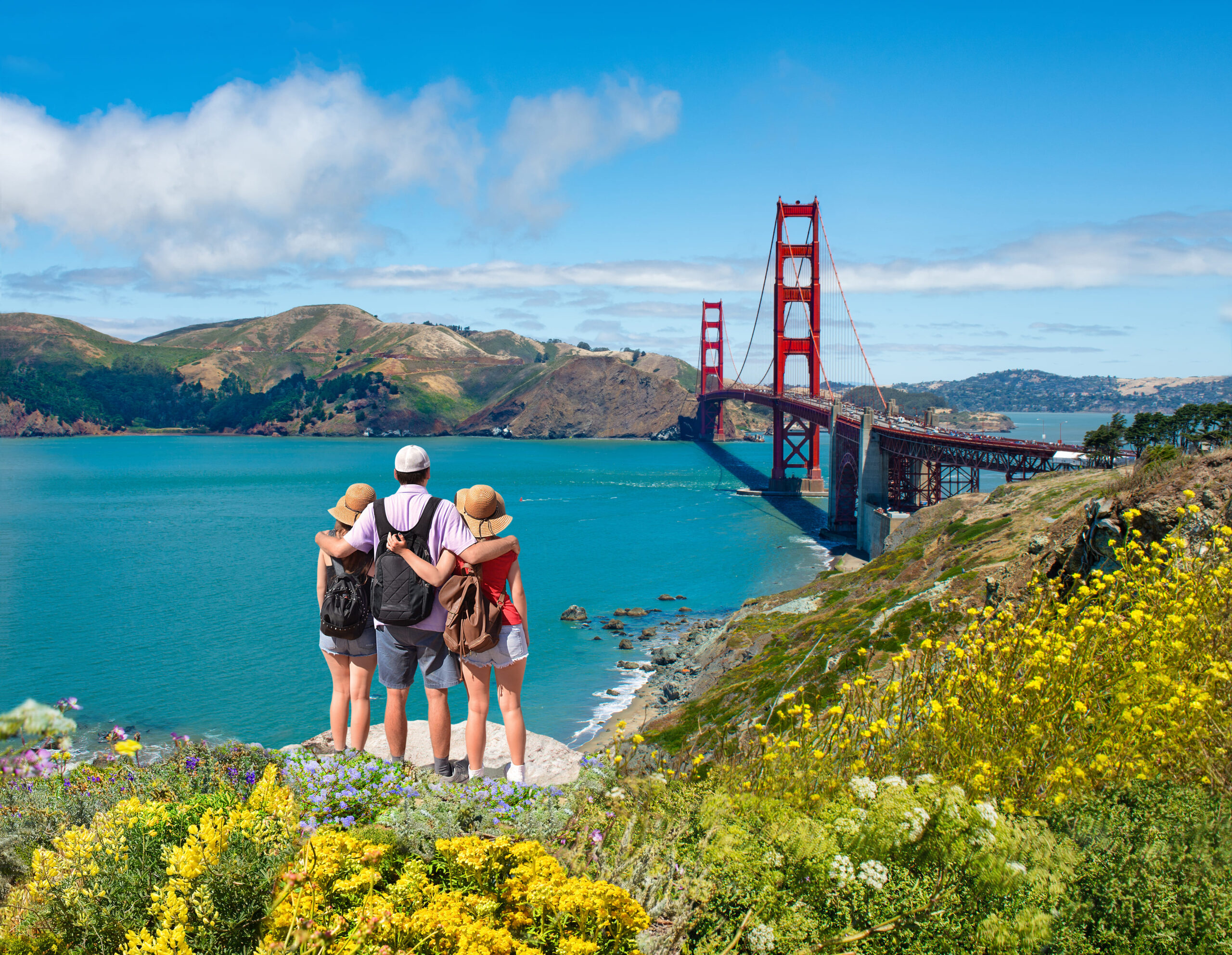 Father with arms around his family looking at the beautiful view of Golden Gate Bridge in San Francisco, CA.<br />
